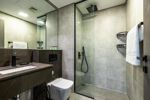 a bathroom with a shower and a toilet and a sink at V2 tower Sports city I Studio in Dubai