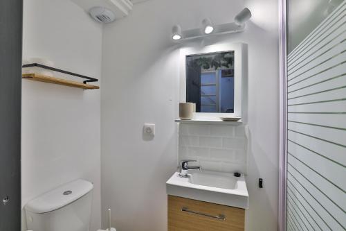 une salle de bain blanche avec un lavabo et un miroir dans l'établissement Studio X O #Hyper-centre #Netflix, à Cognac
