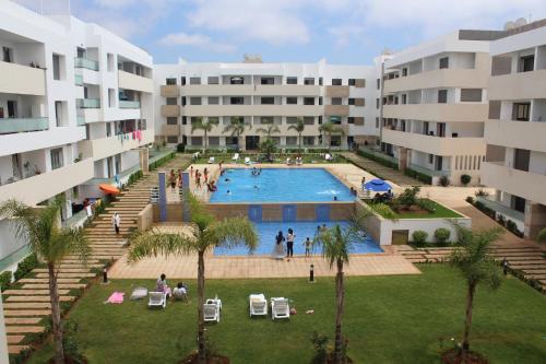 un complejo de apartamentos con piscina en un patio en MOHAMMEDIA 101, en Mohammedia