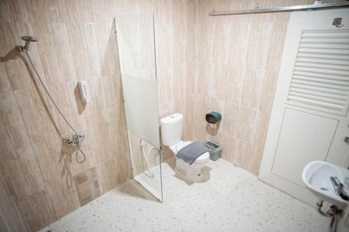 uma casa de banho com um chuveiro, um WC e um lavatório. em Elephant Inn and Suite by Sajiwa em Bandar Lampung