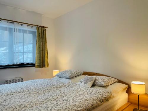 a bedroom with a bed with two pillows and a window at Apartmán Hrabovo L in Ružomberok