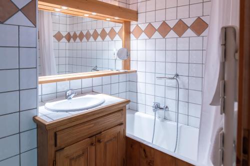 a bathroom with a sink and a tub and a mirror at Bel appartement au coeur du village in Megève
