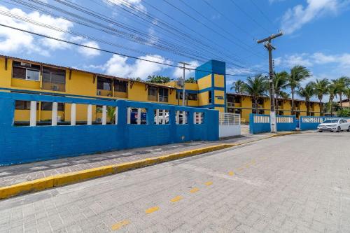 an empty street with a blue and yellow building at Pé na areia, Praia do Francês in Marechal Deodoro