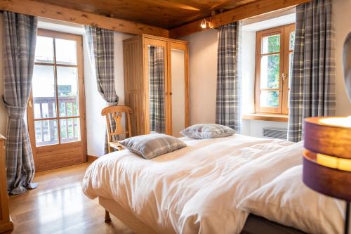 1 dormitorio con 1 cama en una habitación con ventanas en Bel appartement au coeur du village en Megève