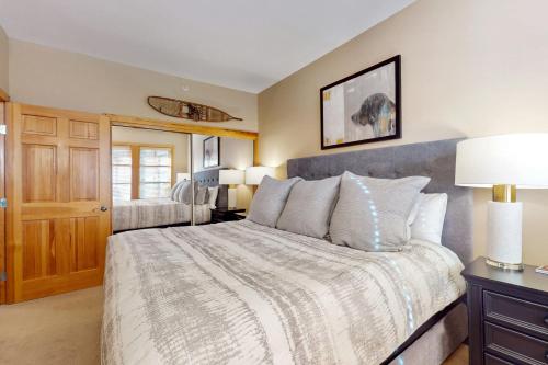 um quarto com uma cama grande e uma mesa com um candeeiro em Passage Point 506 em Copper Mountain