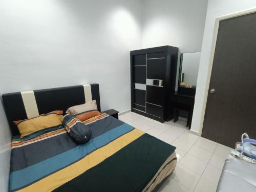 ein Schlafzimmer mit einem großen Bett und einem Spiegel in der Unterkunft HOMESTAY BERTAM SAFAR in Kepala Batas