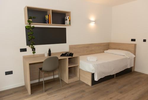 a small bedroom with a bed and a desk at Micampus Burjassot Parque Student Residence in Burjassot