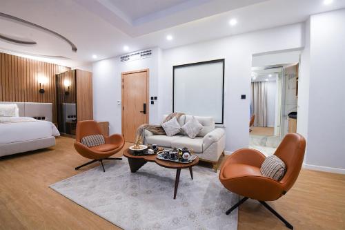 a living room with a bed and a couch and chairs at Arabella Premium Residence - New Cairo in Cairo