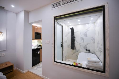 Arabella Premium Residence - New Cairo في القاهرة: حمام مع نافذة زجاجية كبيرة مع دش