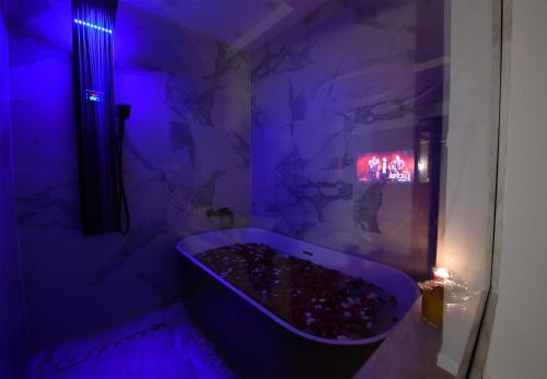 a purple bathroom with a tub filled with rocks at Arabella Premium Residence - New Cairo in Cairo