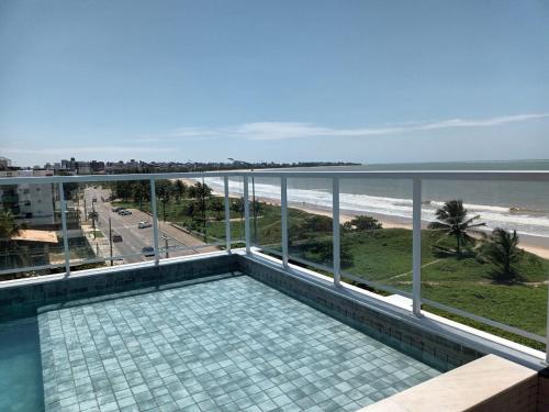 a balcony with a view of the beach and the ocean at Paradise Beach Flat in João Pessoa