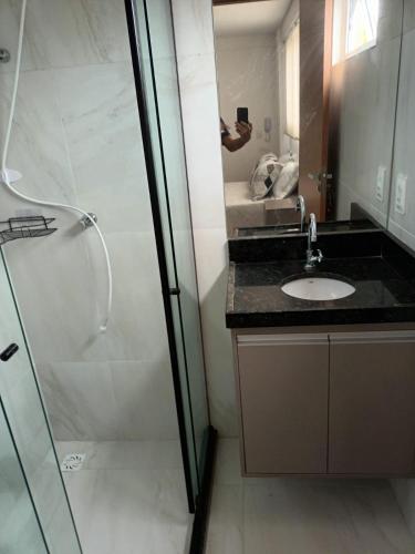 a bathroom with a shower and a sink and a mirror at Paradise Beach Flat in João Pessoa