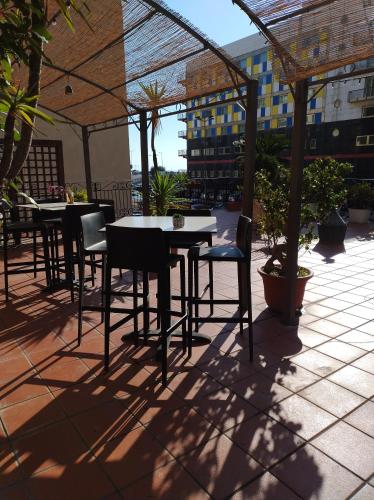 a patio with tables and chairs under a canopy at B&B Mini Hotel Incity-close train station and port- in Salerno