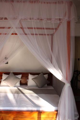 a bedroom with a bed with a canopy at THE LODGE in Mirissa