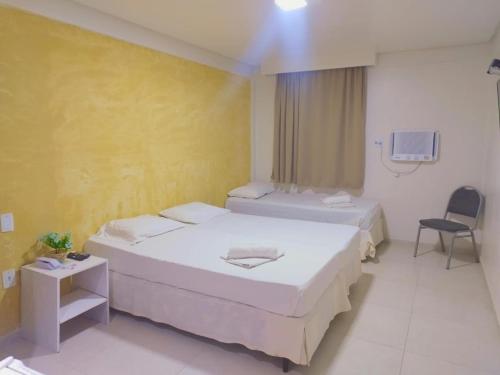 a hotel room with two beds and a tv at Hotel Boa Viagem Aeroporto in Recife