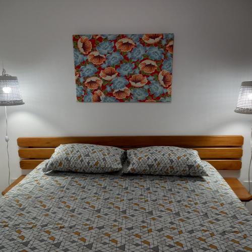 a bedroom with a bed with a floral picture on the wall at Apartamento inteiro n.24 in Porto Seguro