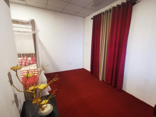 Habitación con cortinas rojas y alfombra roja. en Villa Sea View en Galle