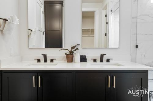 a bathroom with a sink and two mirrors at Luxurious Modernism with Private Hot Tub and Garage in Austin
