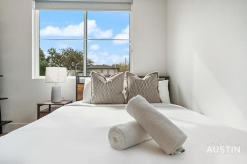 a white bed with a stuffed animal on top of it at Luxurious Modernism with Private Hot Tub and Garage in Austin