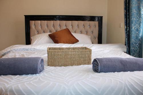 a bed with two pillows and a basket on it at Zeni apartment in Meru