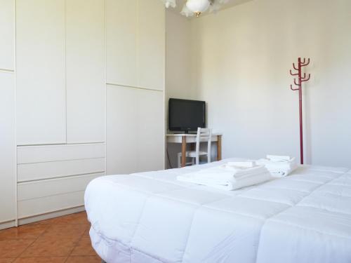 a white bedroom with a bed and a television at A casa di Titti Arezzo in Arezzo