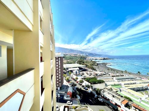 uitzicht op het strand vanaf het balkon van een gebouw bij Apartmento a 150m de playa, con piscina climatizada in Puerto de la Cruz