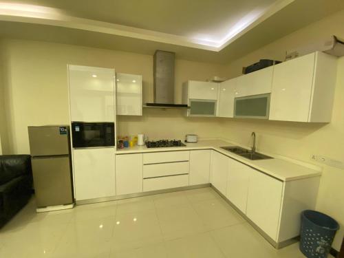a kitchen with white cabinets and a stainless steel refrigerator at 1 bed apartment infront of Centaurus in Islamabad