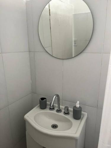 ein weißes Badezimmer mit einem Waschbecken und einem Spiegel in der Unterkunft Casa a 400 M de la playa in Mar del Plata