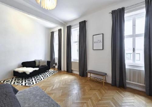 een woonkamer met een bank en een aantal ramen bij Luxurious, 2 min to Casino and Römertherme in Baden