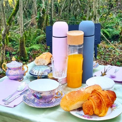 Una mesa con croissants y una taza de jugo de naranja. en Logements Insolites, Les Rêves d'Ambre, 
