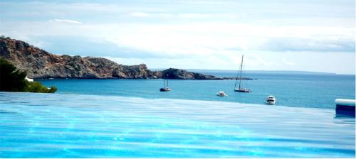 a swimming pool with boats in the water at Villa Rica Beach in Ibiza Town