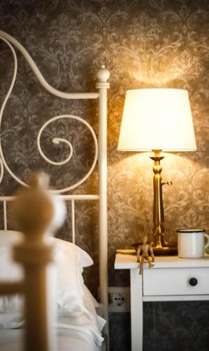 a lamp sitting on a table next to a bed at Guest House Camilla in Alghero