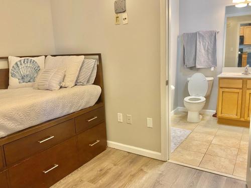 a bedroom with a bed and a bathroom with a toilet at Coastal Oasis Retreat at The Palms of Destin! in Destin