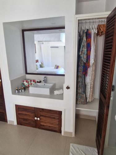 a bathroom with a sink and a mirror at Dhow Inn Boutique Hotel in Paje