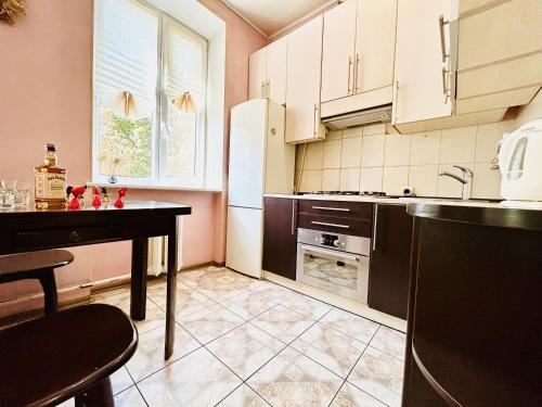 eine Küche mit einem Tisch und einem Kühlschrank in der Unterkunft Kholodnaya gora in Kharkov