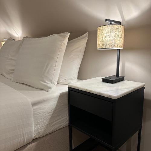 a bed with white pillows and a lamp on a night stand at Hotel Grand Canal in Delft