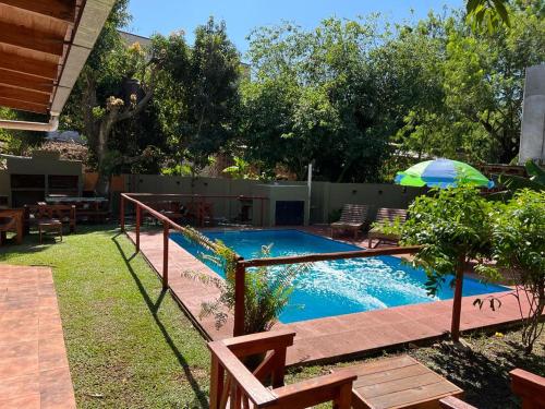 a swimming pool in a backyard with an umbrella at Cabañas Vacaciones Copadas VC in Puerto Iguazú