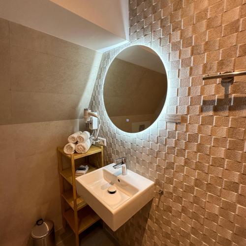 a bathroom with a sink and a mirror at Hotel Grand Canal in Delft