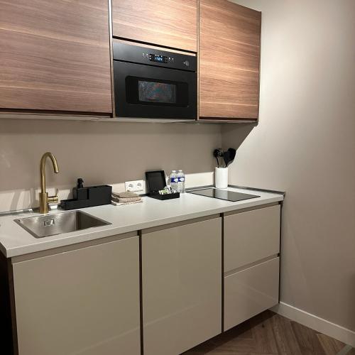 a kitchen with a sink and a microwave at Hotel Grand Canal in Delft