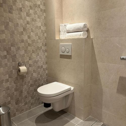 a bathroom with a toilet and some towels at Hotel Grand Canal in Delft