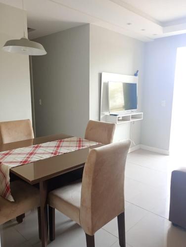 a dining room with a table and chairs and a television at apartamento confortavel no aracagir ,1 km da praia. in São Luís