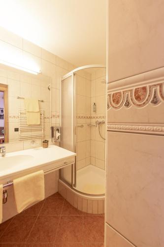 a bathroom with a shower and a sink and a tub at Hotel Sonnenheim in Sankt Anton am Arlberg