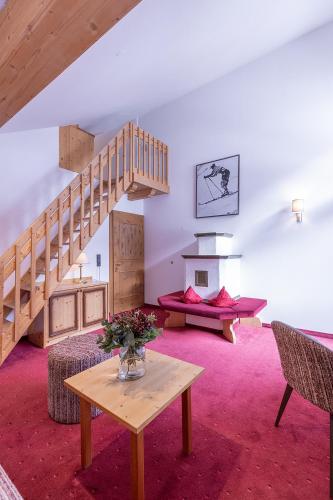 a living room with a staircase and a table at Hotel Sonnenheim in Sankt Anton am Arlberg