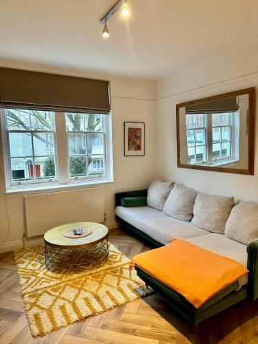 a living room with a couch and a table at Bright and Airy Two Bedroom Apartment in London