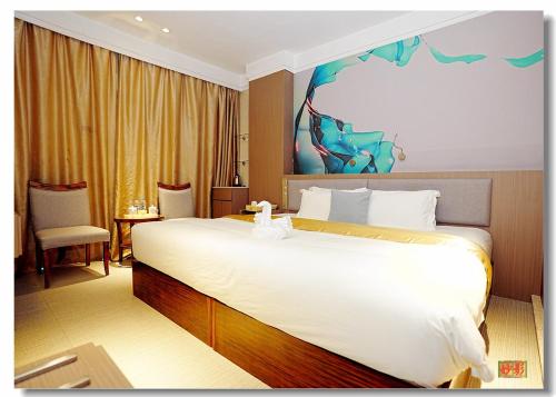 a hotel room with a large bed and a painting on the wall at pristine 1 in Manila
