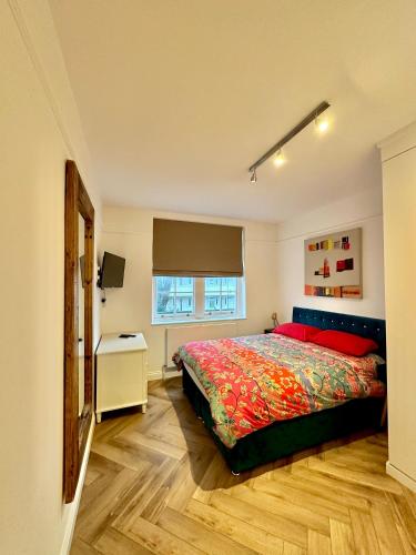 Schlafzimmer mit einem Bett und einem Fenster in der Unterkunft Bright and Airy Two Bedroom Apartment in London