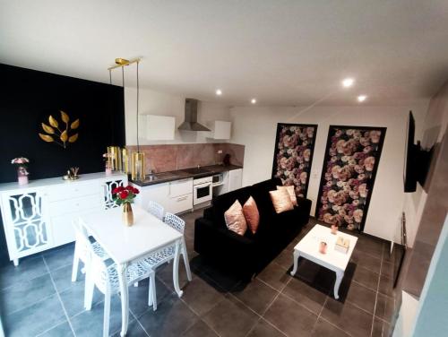 un salon avec un canapé et une table et une cuisine dans l'établissement Cocon romantique avec jacuzzi extérieur, à Rosières-près-Troyes