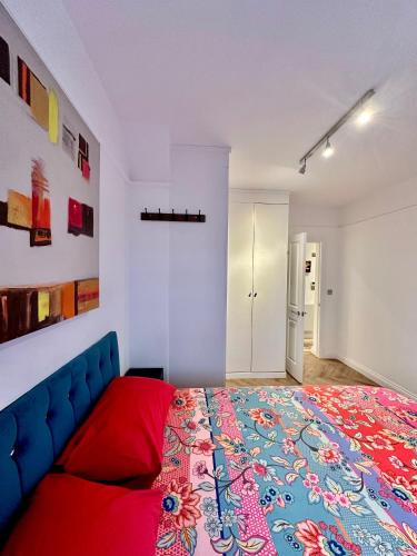 a bedroom with a large bed with a blue couch at Bright and Airy Two Bedroom Apartment in London