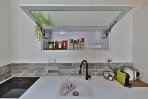 a sink in a kitchen with a window above it at דירות קו ראשון לחוף - Apartments First line to the Beach in Qiryat Yam
