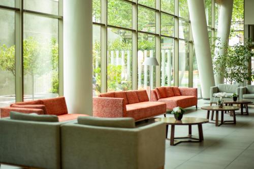 a lobby with couches and tables and large windows at abba Presidente Suites Santiago in Santiago